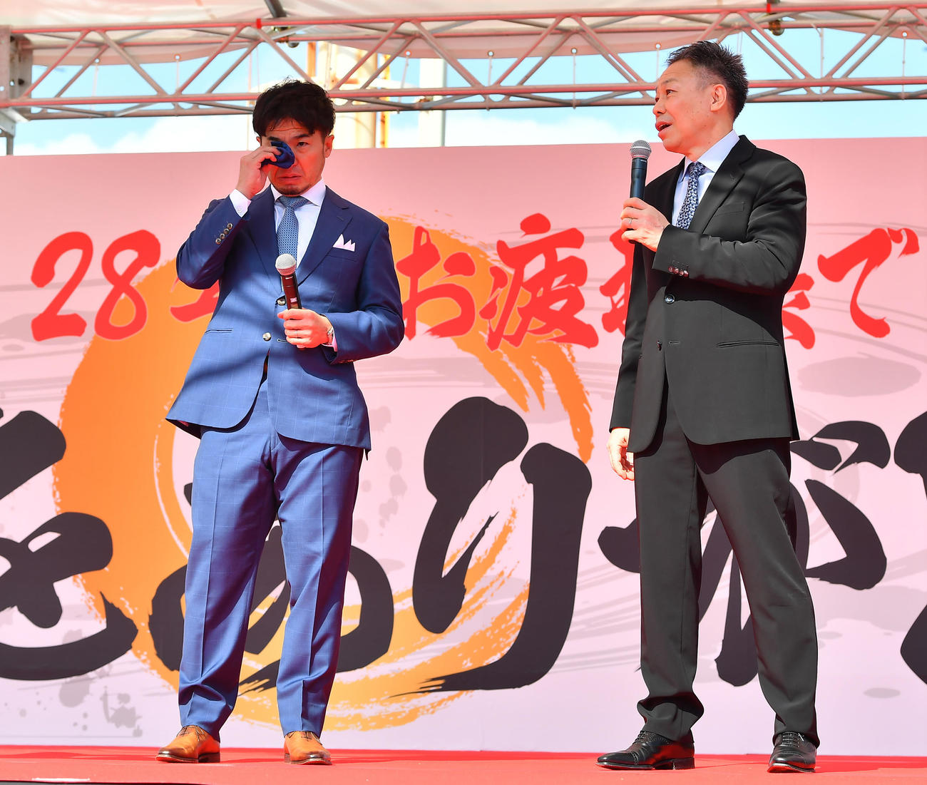引退報告会でサプライズ登場した松本整氏（右）の話を涙ながらに聞く村上義弘氏