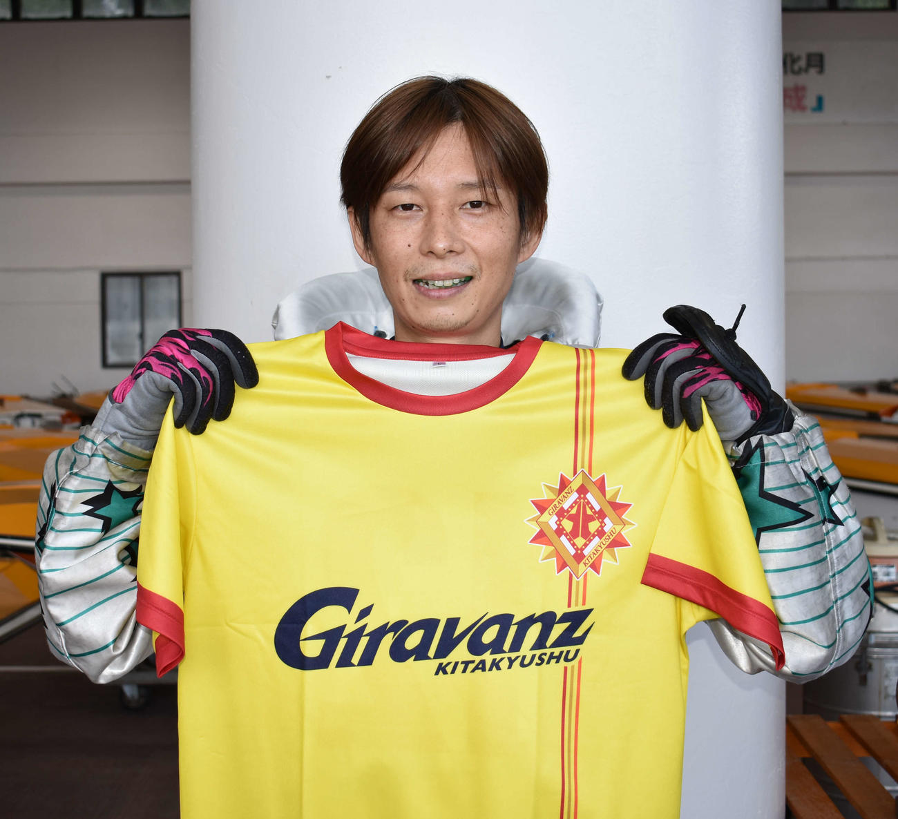 芦屋初優勝を果たした中田元泰はJ北九州のユニホームを手に笑顔を浮かべる