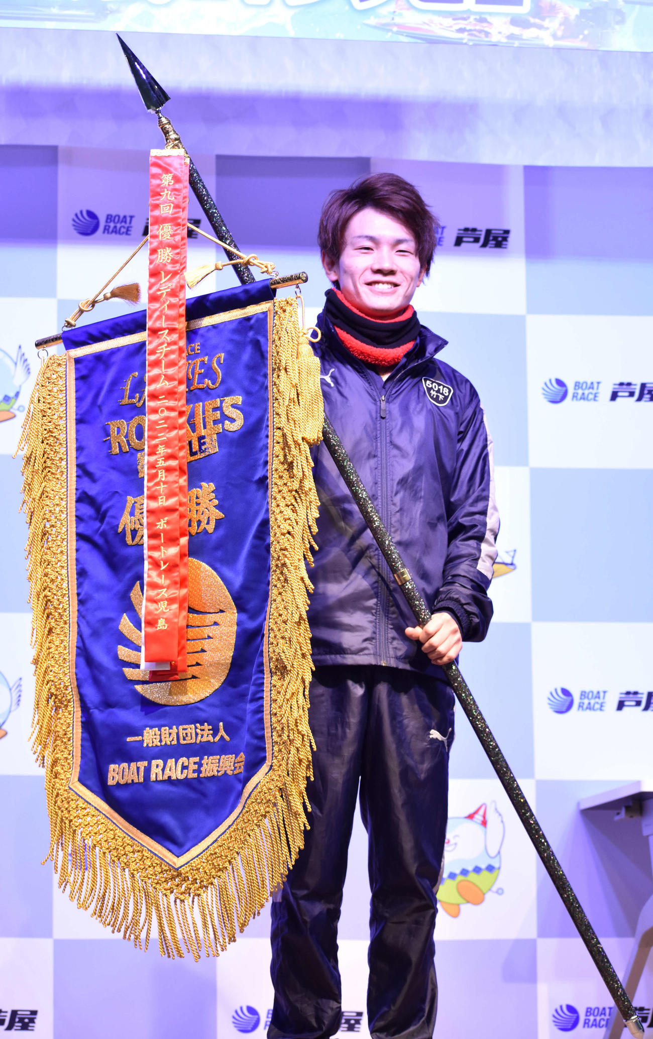 団体戦で勝利したルーキーズ代表の竹下大樹が優勝旗を手に笑顔