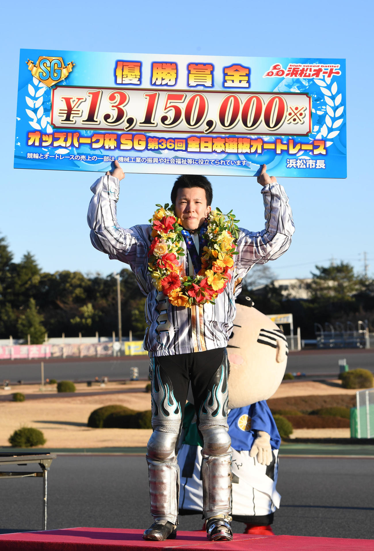 優勝し賞金ボードを掲げる鈴木圭一郎（撮影・柴田隆二）