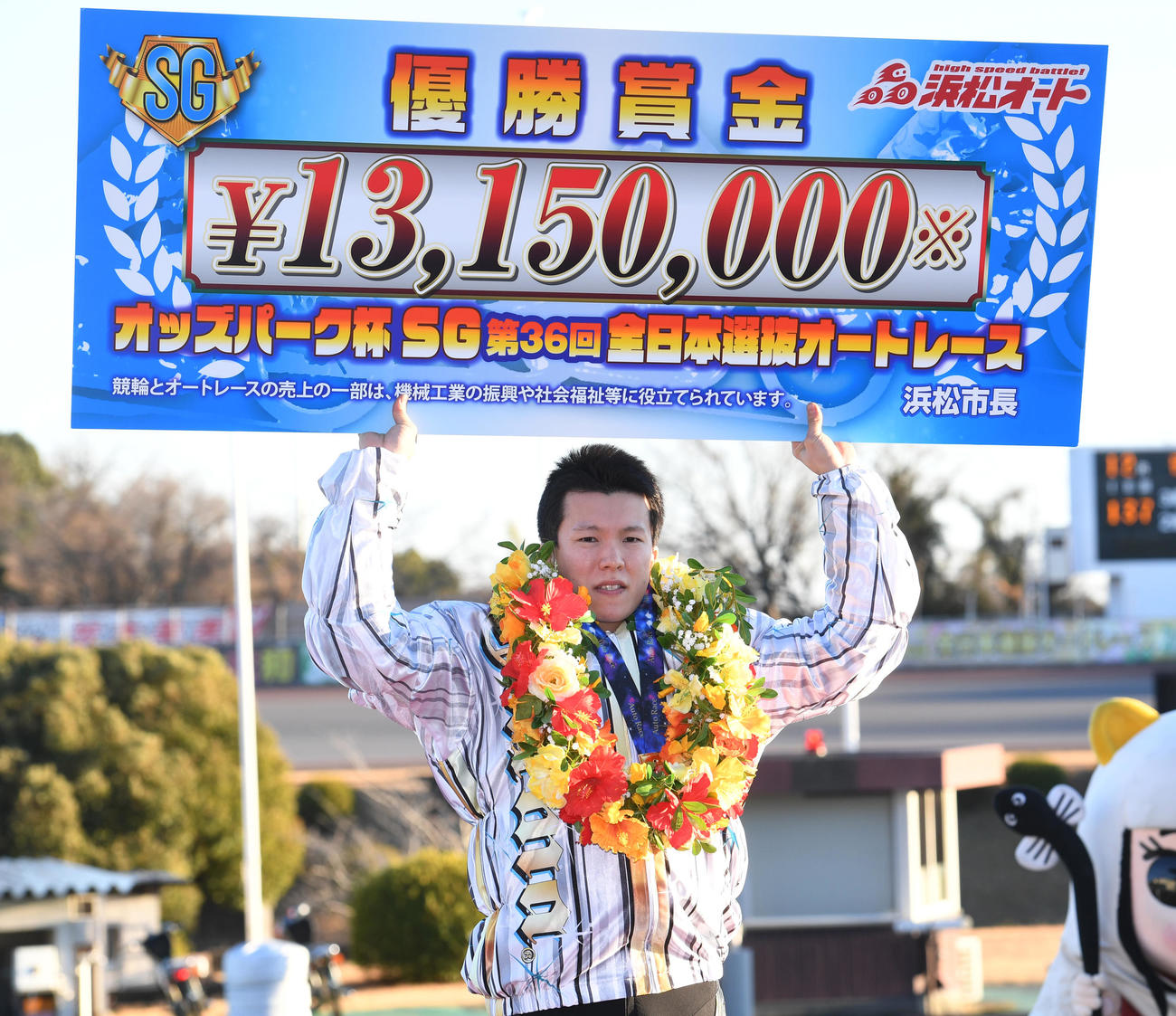 優勝し賞金ボードを掲げる鈴木圭一郎（撮影・柴田隆二）