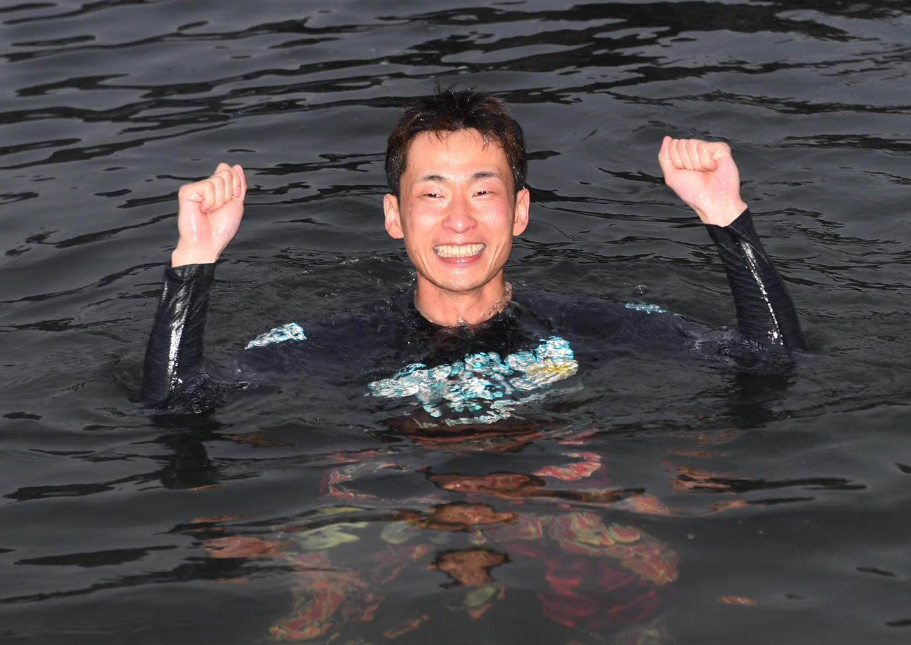 優勝した土屋智則は水神祭で水面に投げ込まれガッツポーズする（撮影・柴田隆二）