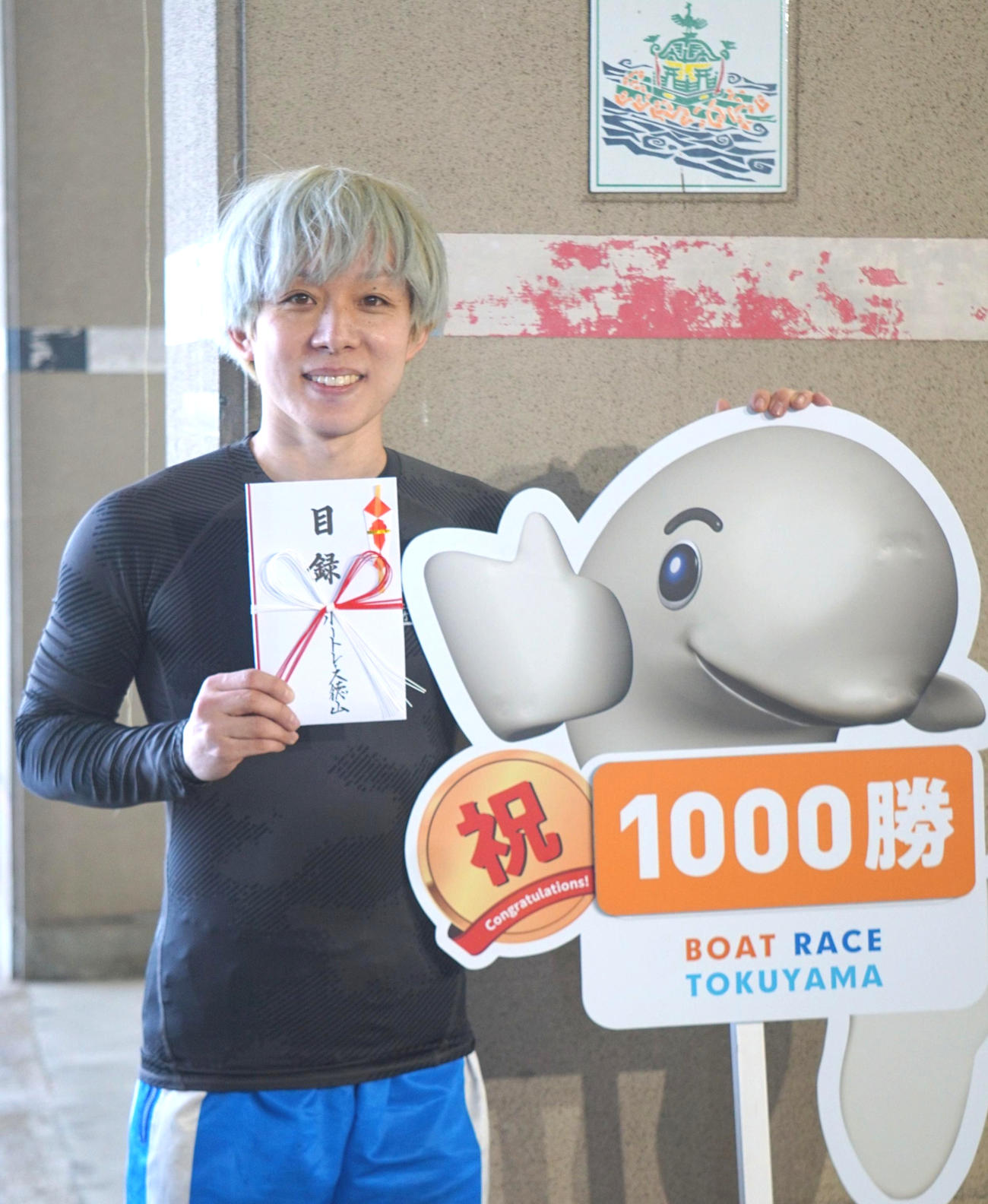 竹田辰也は1000勝記念のパネルと目録を手に笑顔をみせた