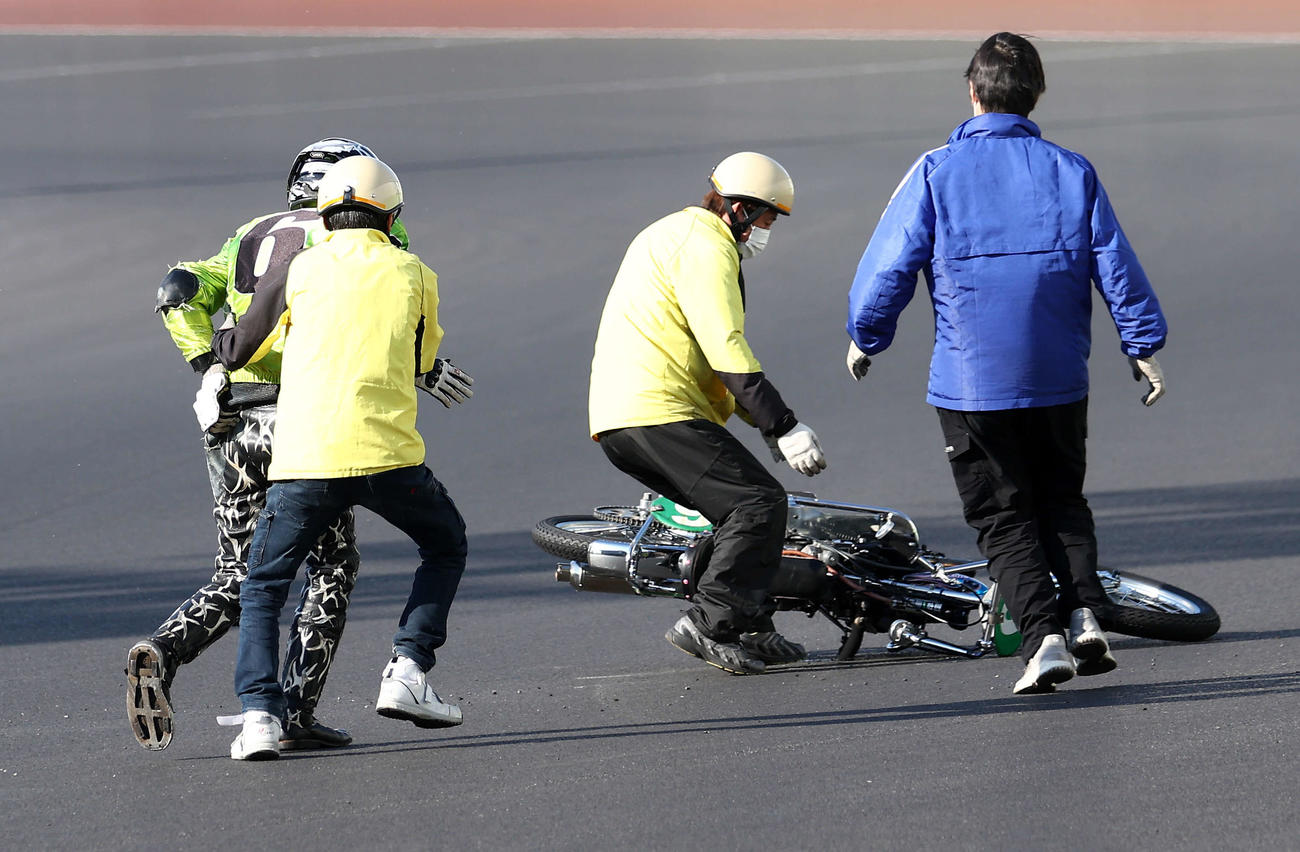 準決勝11R　落車した森且行（左）はスタッフの手を借りバンクから移動する（撮影・河田真司）
