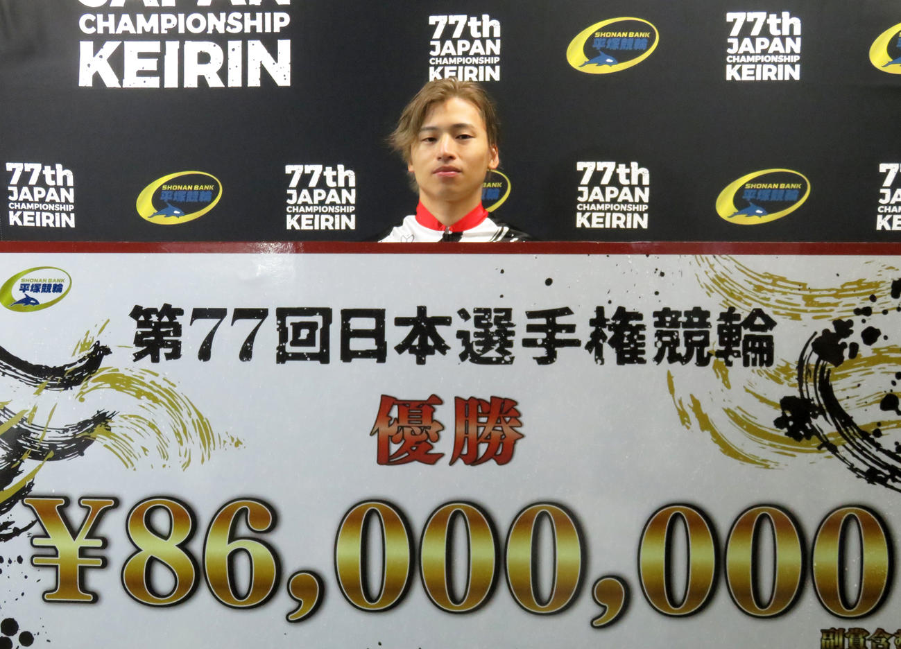 賞金ボードを手にする山口拳矢