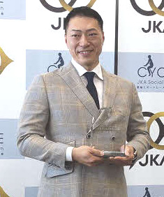 グランドスラム達成の記念盾を手に笑顔を見せる新田祐大