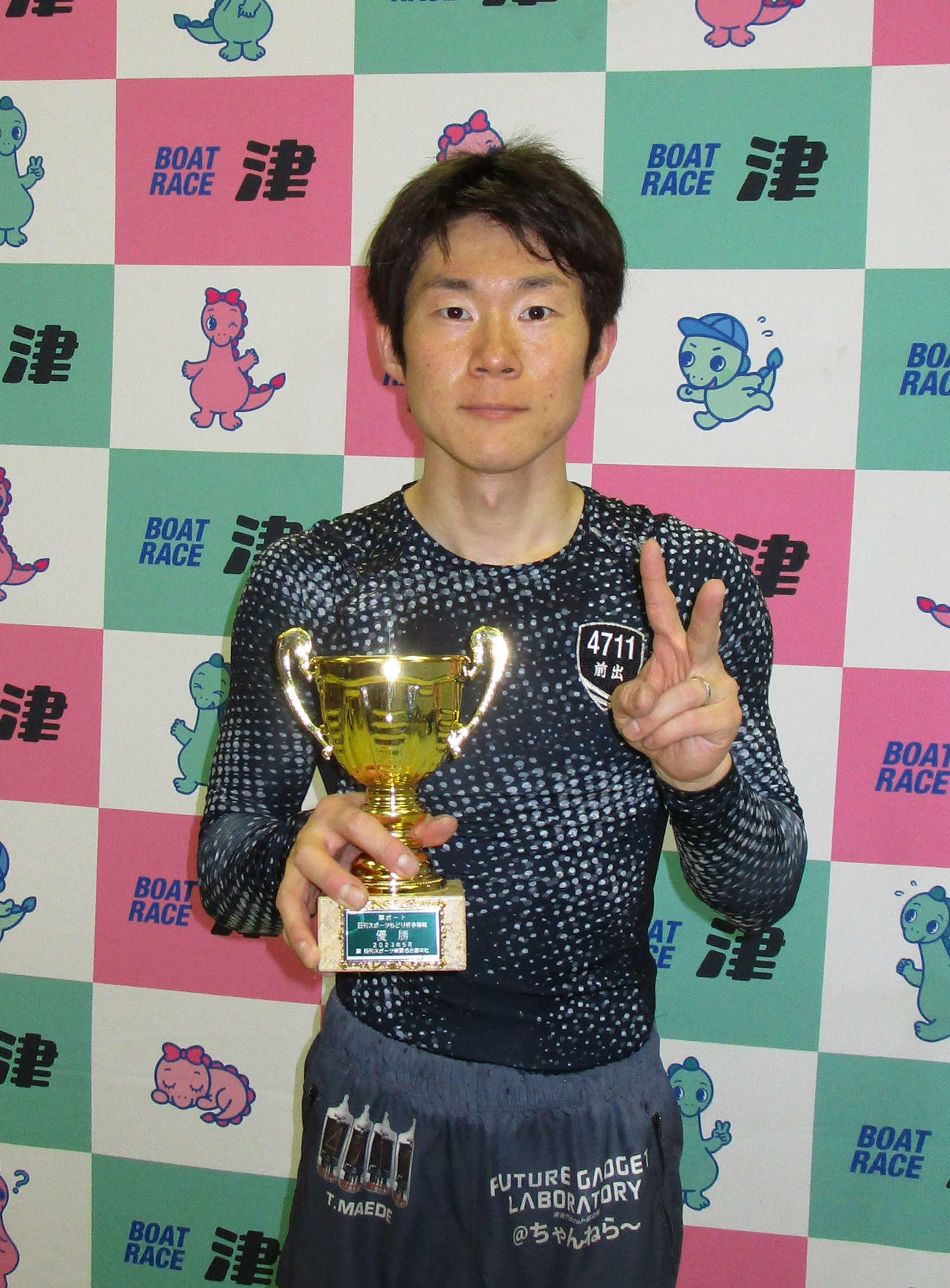デビュー初優勝を決め、トロフィーを手にVサインの前出達吉