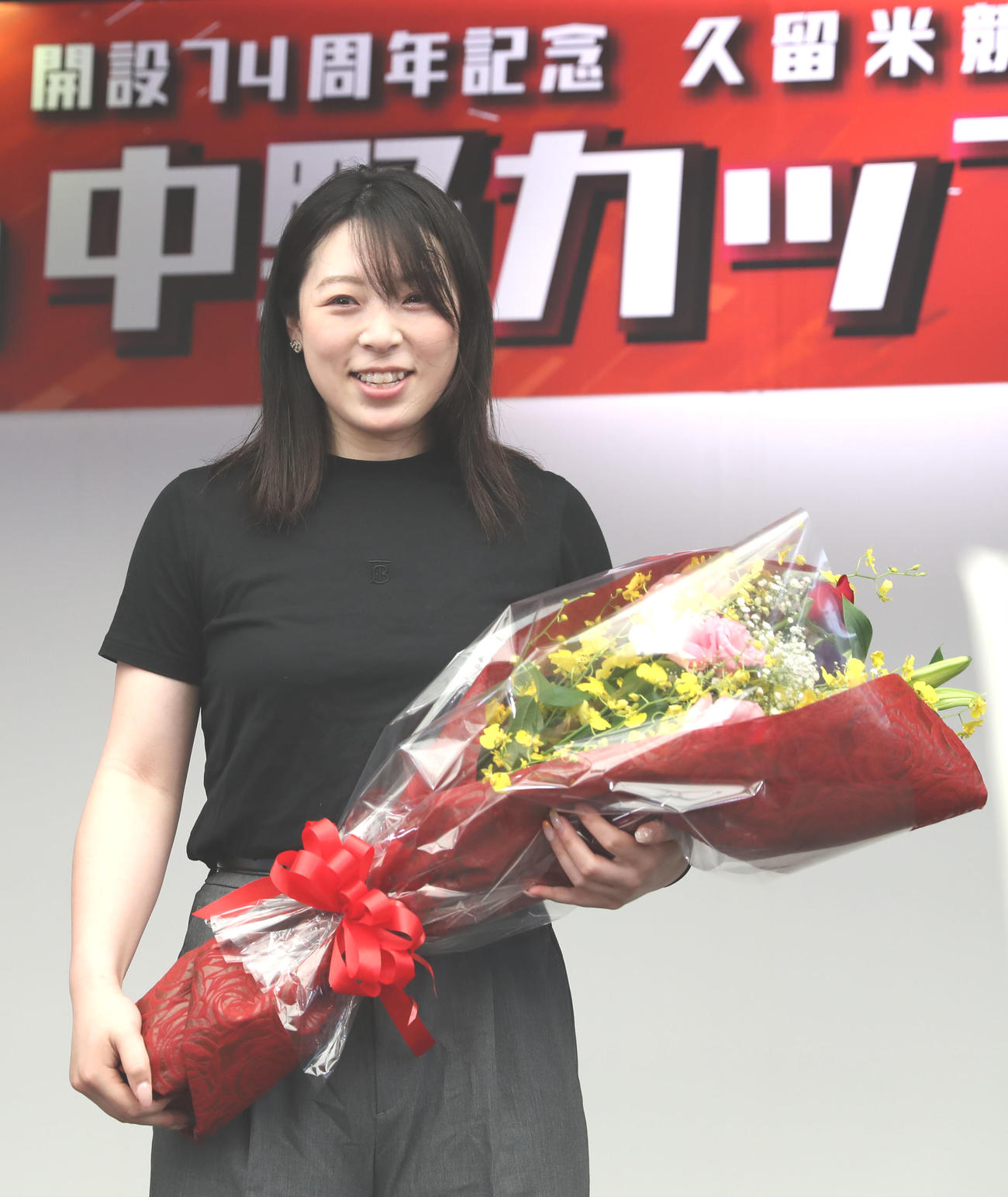優勝報告会で花束を手に笑顔を見せる児玉碧衣（撮影・冨田成美）