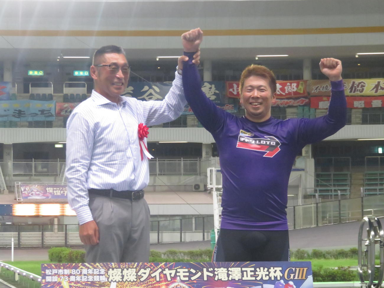 日本競輪選手養成所の滝沢正光所長（左）に称えられる深谷知広