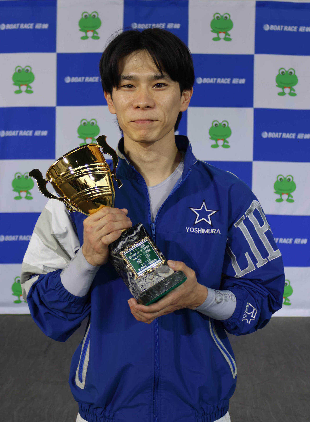 吉村誠がイン圧勝でV。優勝カップを手にして笑顔を見せた