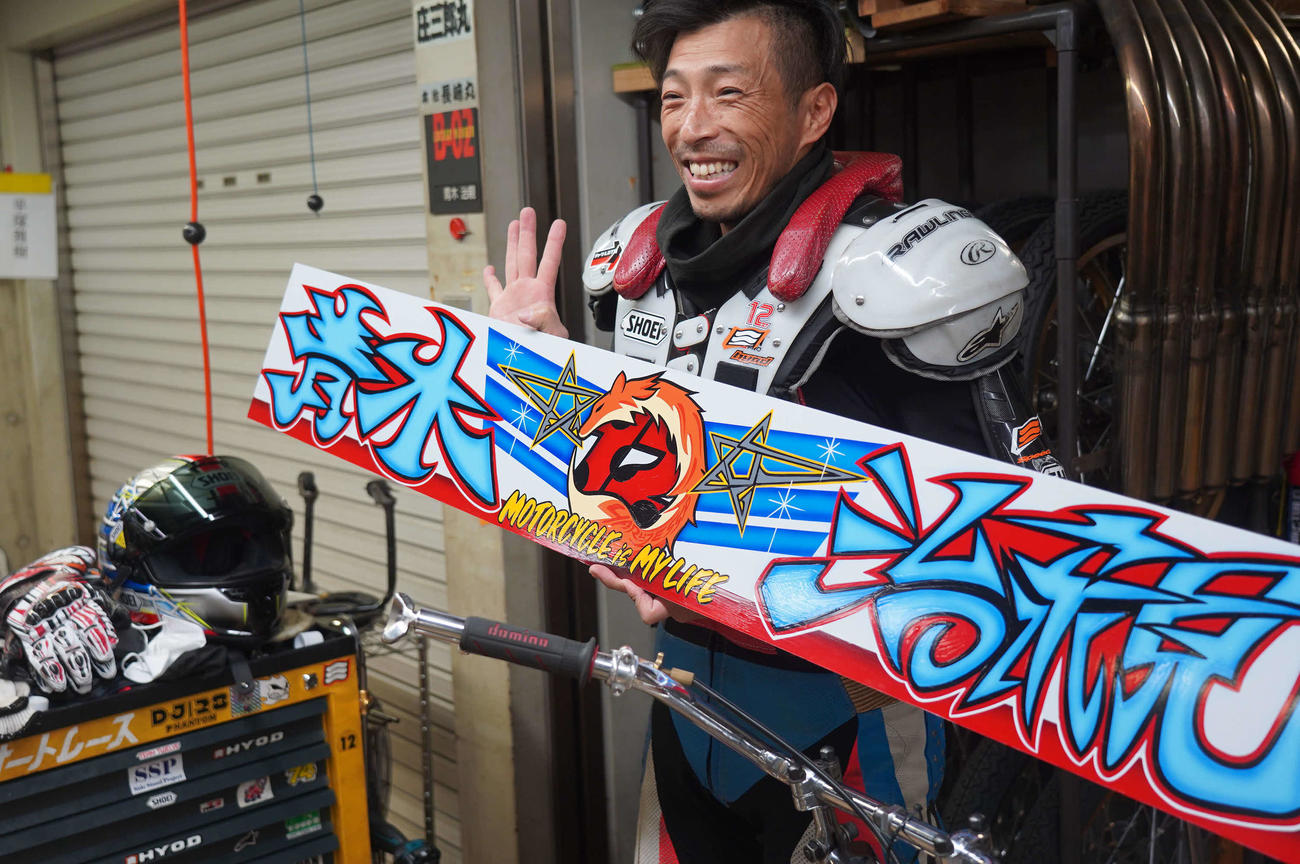 青木治親が通算400勝達成。今度掲示される横断幕のデザインを手に持ち笑顔で記念撮影