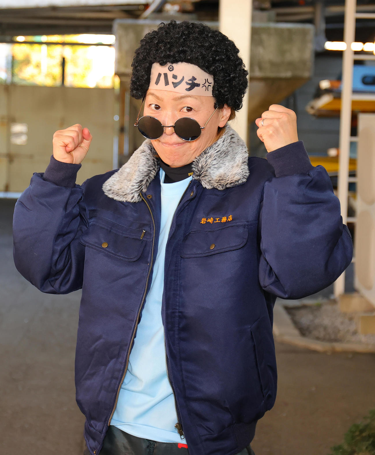 11R1着の岩崎芳美は、「岩崎工務店」のジャンパー、パンチパーマのカツラをかぶりガッツポーズ（撮影・野上伸悟）
