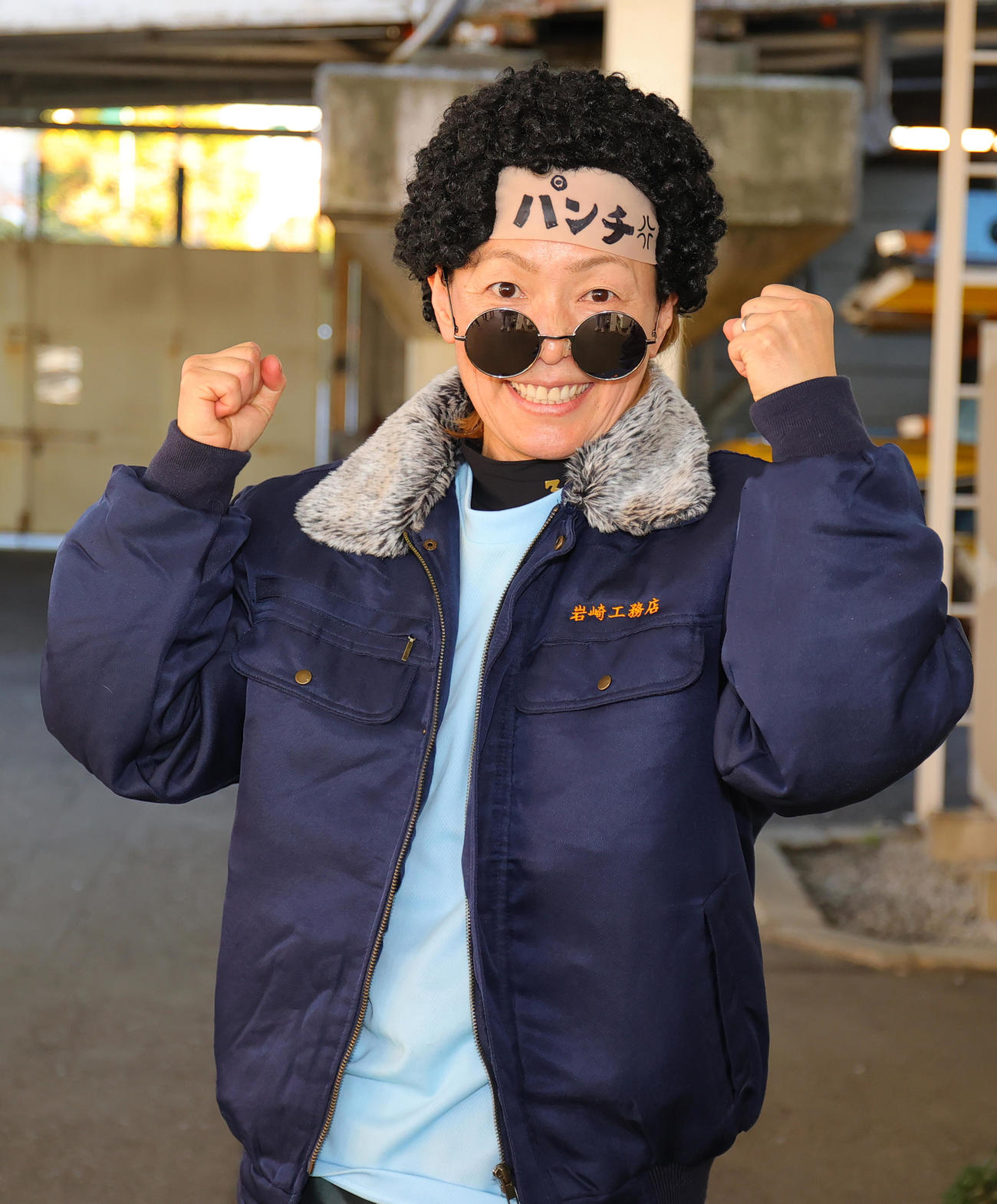 11R1着の岩崎芳美は、「岩崎工務店」のジャンパー、パンチパーマのカツラをかぶりガッツポーズ（撮影・野上伸悟）