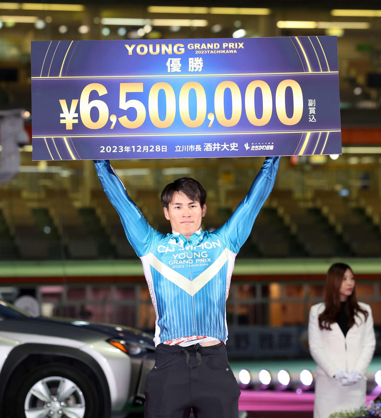 賞金ボードを手にする太田海也（撮影・鈴木正人）