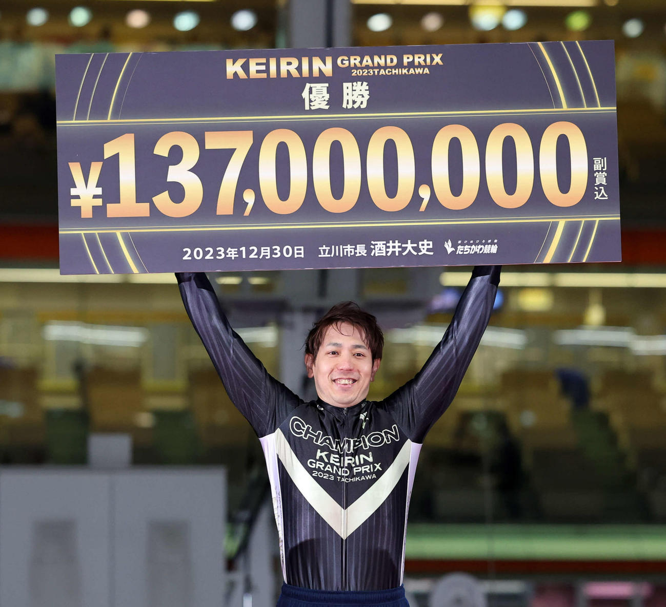 KEIRINグランプリを初制覇し、賞金ボードを掲げながら笑顔の松浦悠士（撮影・鈴木正人）