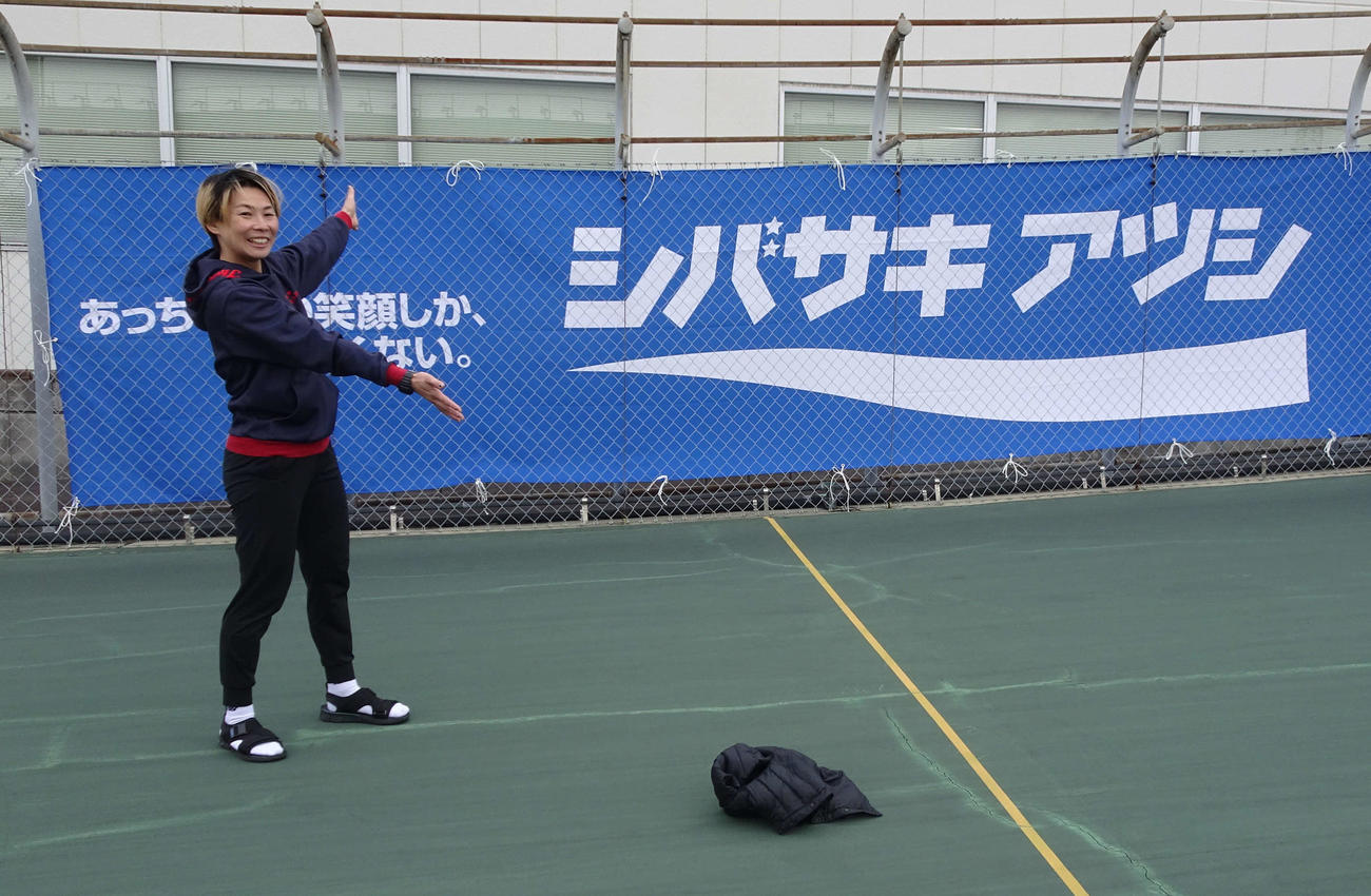 小坂知子があっちゃんの横断幕の前で笑顔