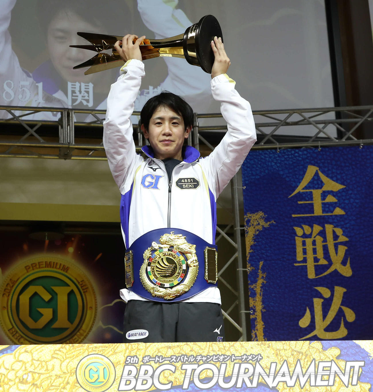 チャンピオンベルトとトロフィーを手にした関浩哉（撮影・冨田成美）