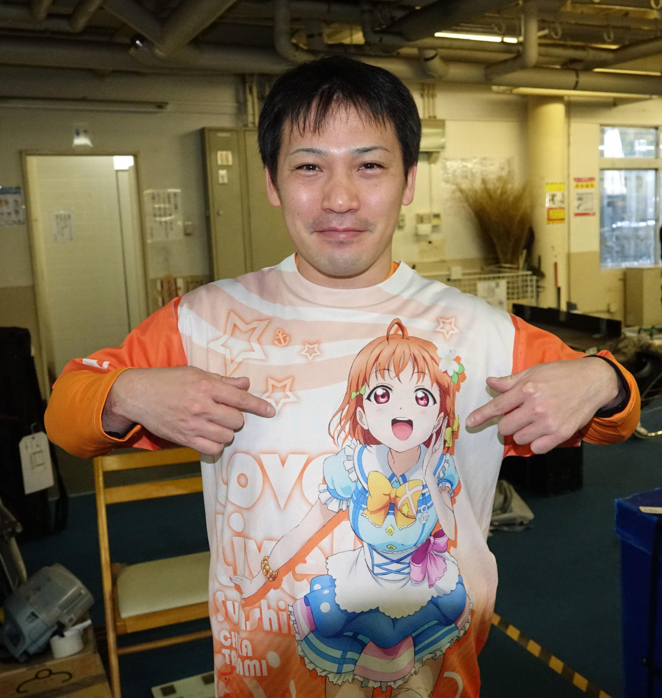 お気に入りのアニメ「ラブライブ」のシャツを指さす玉村元気