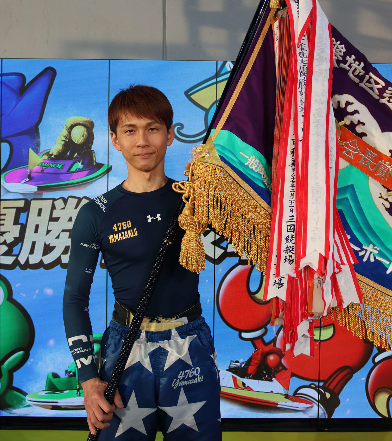 山崎郡が待望のG1タイトルを初戴冠。優勝旗を手に笑みを浮かべた