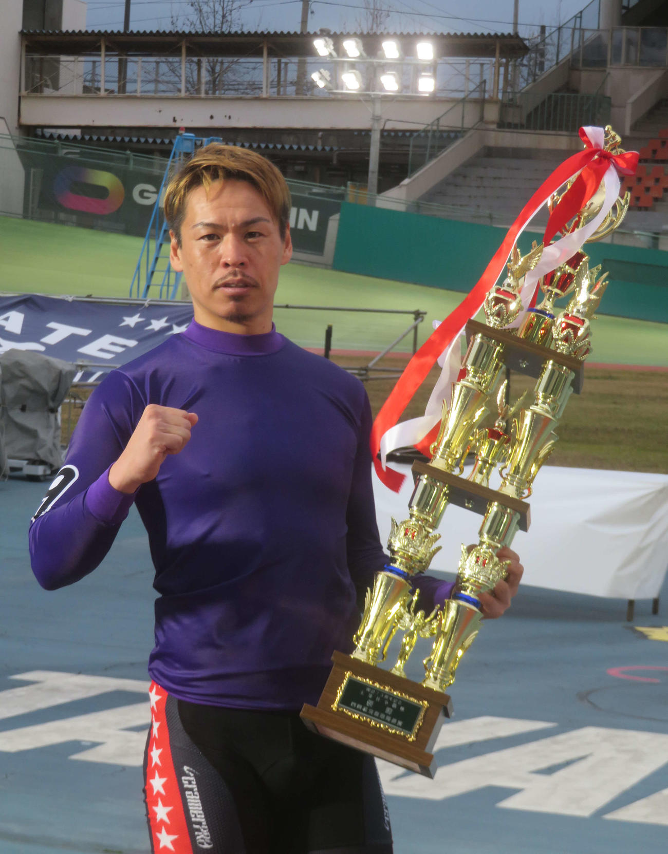 優勝トロフィーを抱えてガツポーズする浅井康太