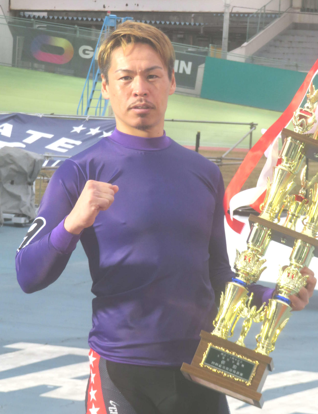 優勝トロフィーを抱えてガツポーズする浅井康太