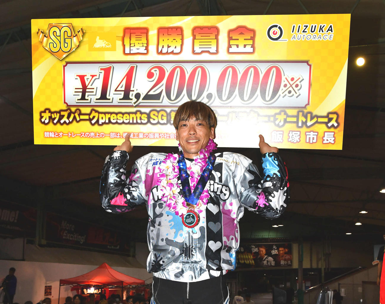 賞金ボードを掲げる青山周平（撮影・岩下翔太）