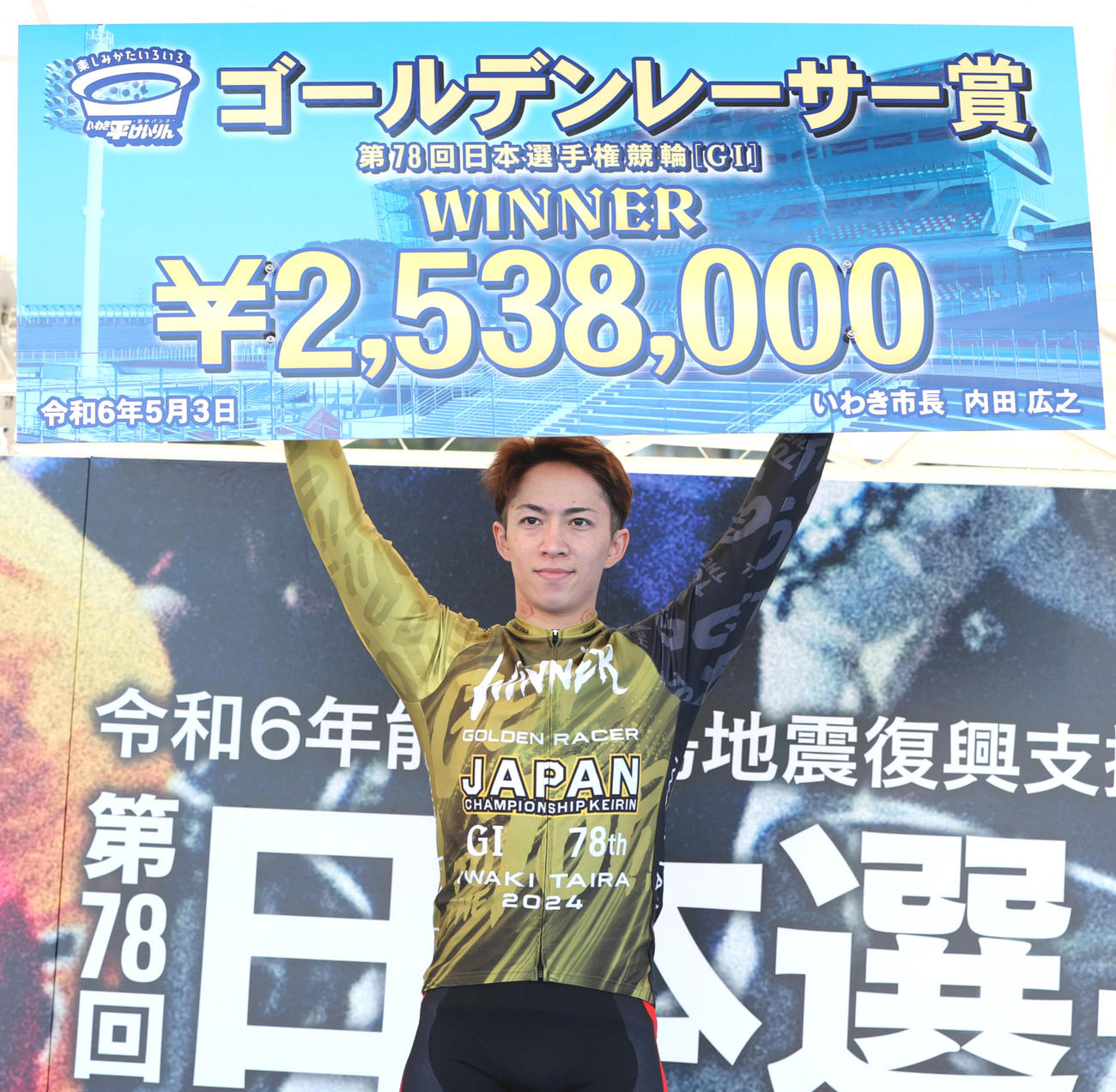 ゴールデンレーサー賞を制し賞金ボードを掲げる坂井洋