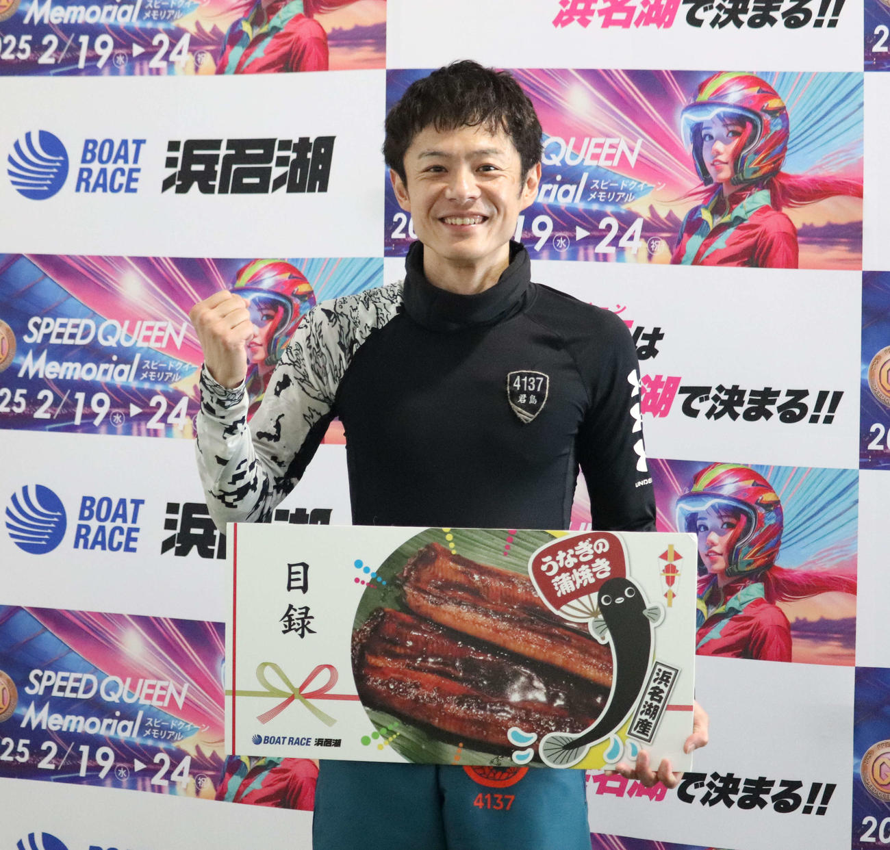 記念品の目録を手に笑顔の君島秀三