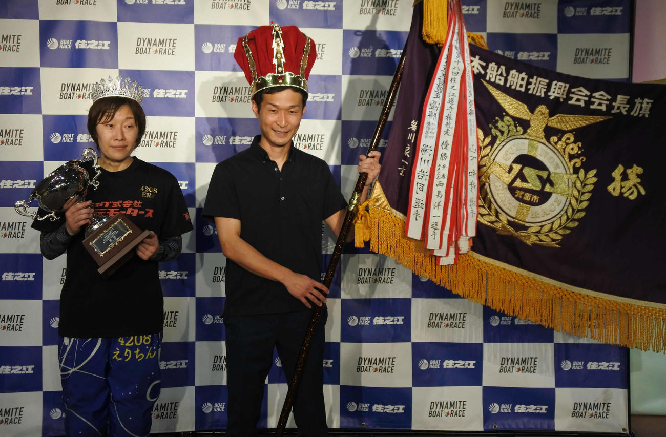 三浦永理はティアラ、岡村慶太は王冠と優勝旗を持ってにっこり微笑む
