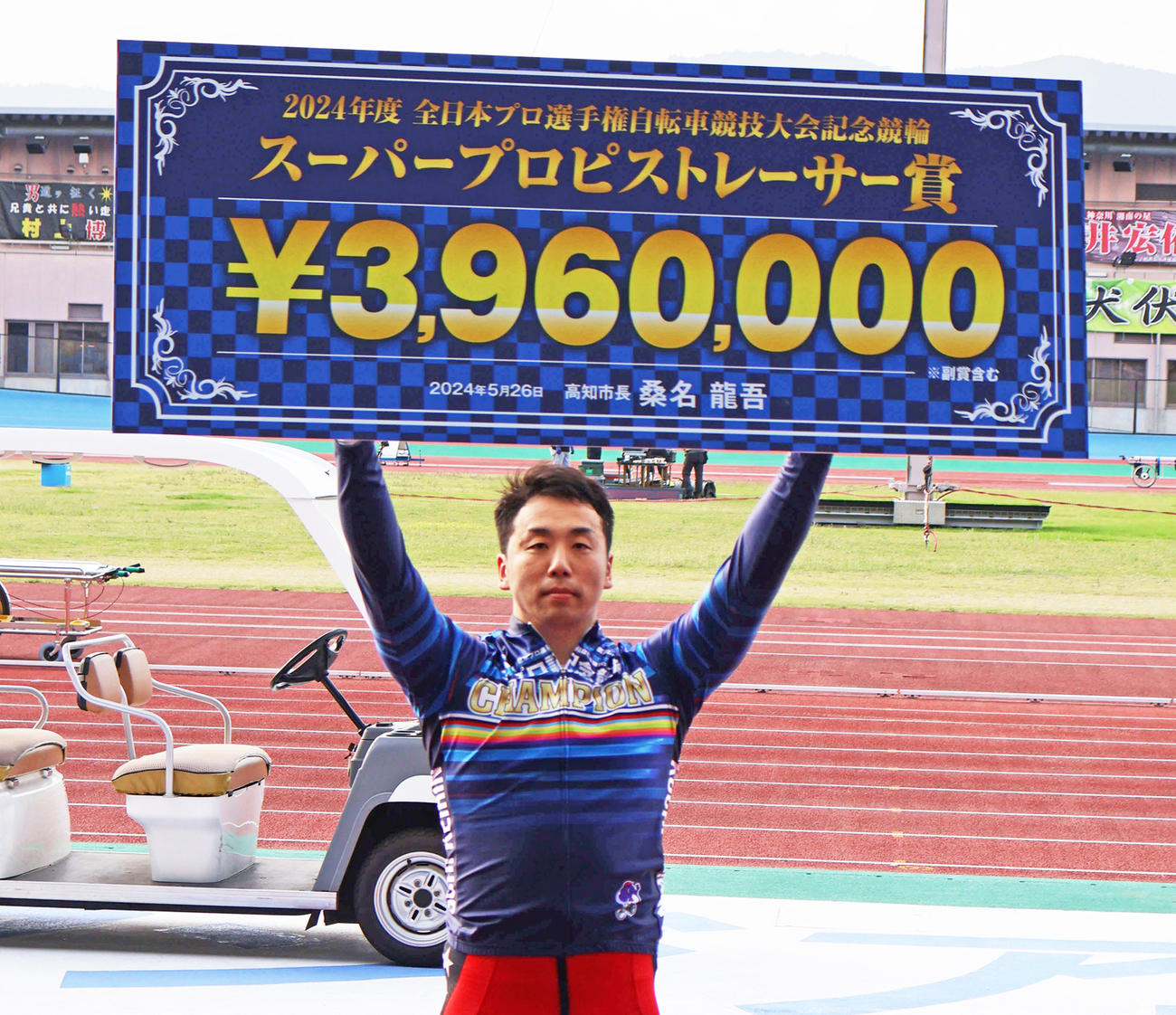 優勝した清水裕友は賞金ボードを掲げる