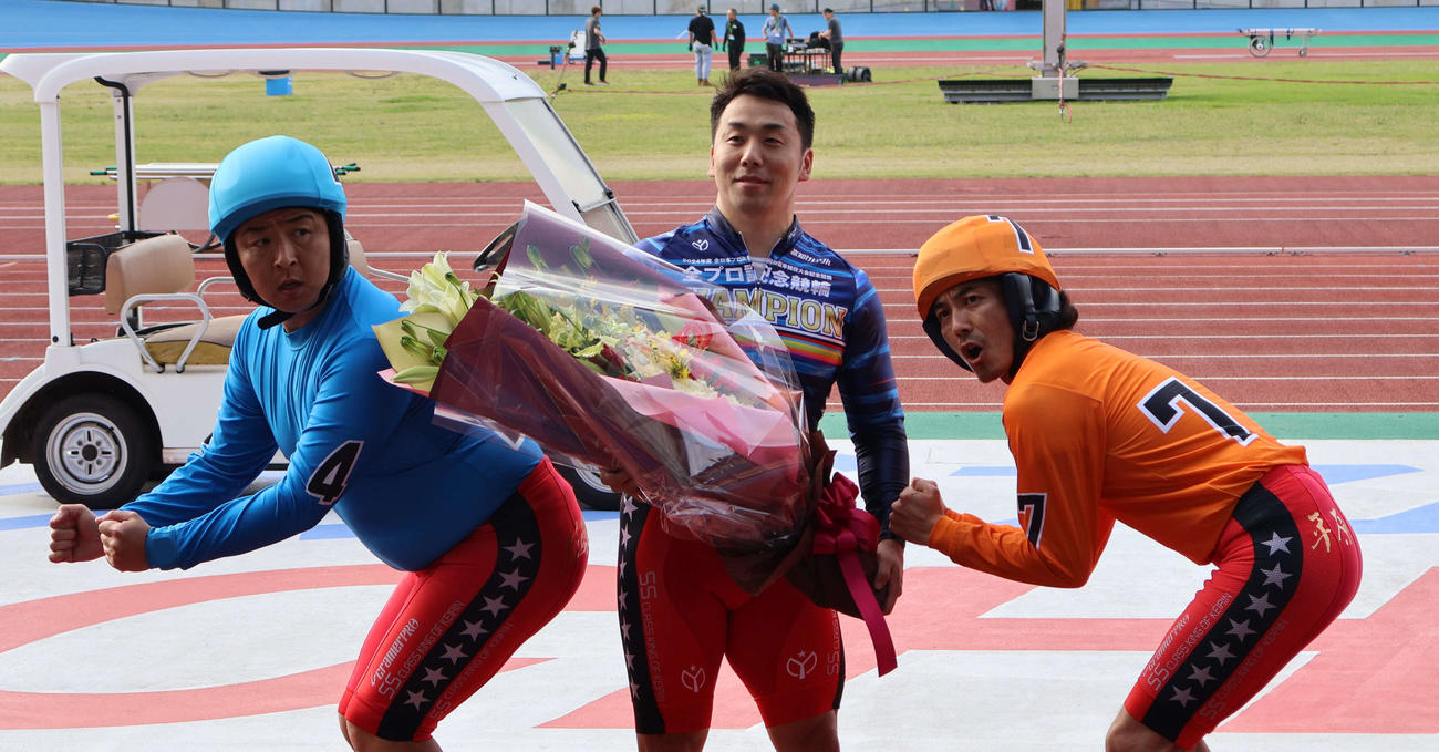 優勝した清水裕友（中央）はお笑いコンビどりあんずに自転車ポーズで祝福された