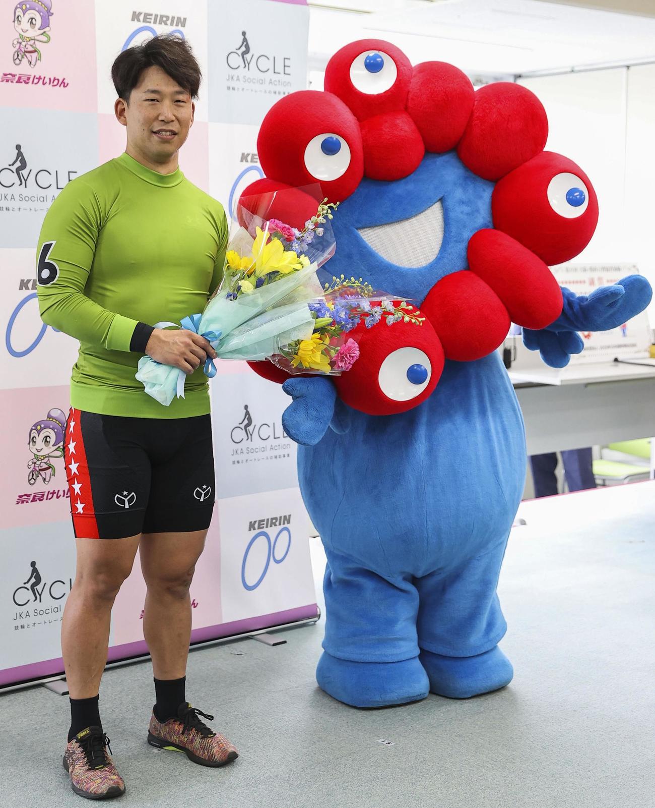 万博公式キャラクター「ミャクミャク」に祝福され笑顔の大矢崇弘