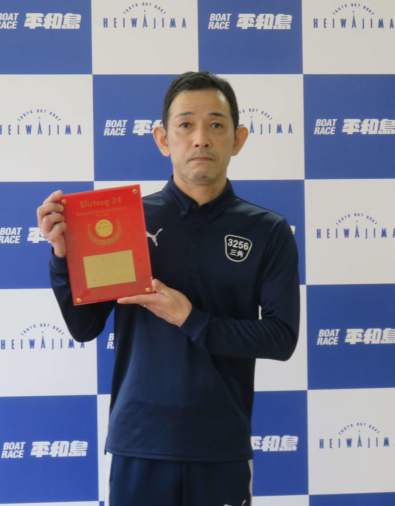 全24場制覇を達成した三角哲男が、記念の表彰盾を受けた
