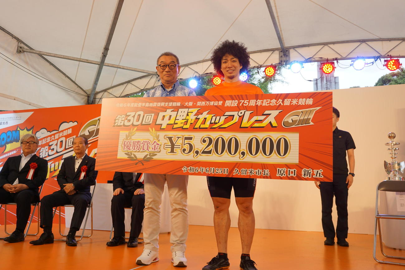 優勝した山崎賢人は賞金ボードを手に笑顔（左は中野浩一氏）