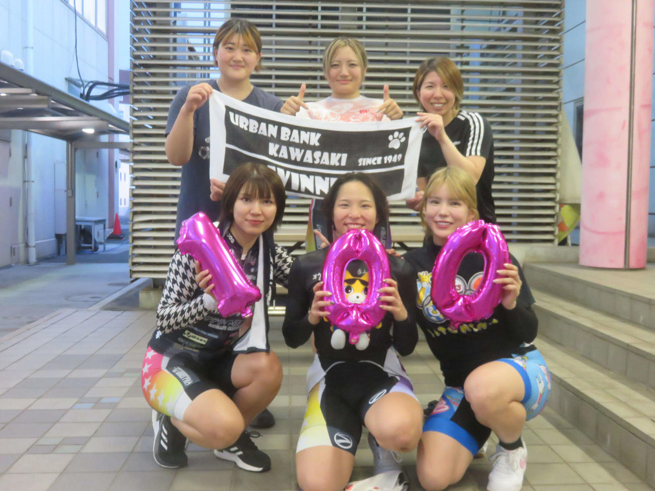 節目の100勝を達成した当銘直美（下段中央）は仲間たちに囲まれ笑顔