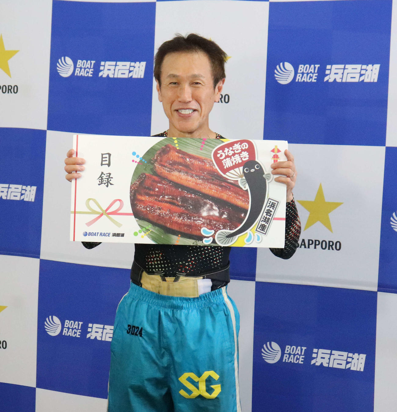副賞の目録を手に笑顔の西島義則