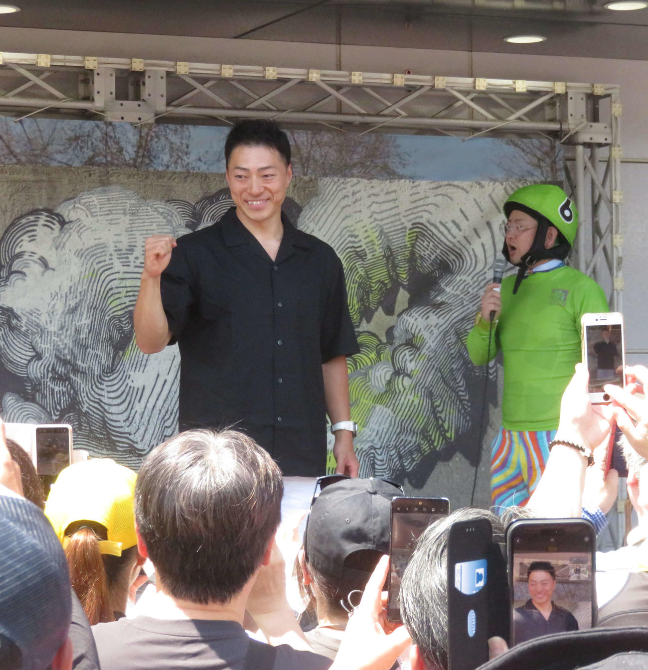 松戸競輪　ファンにカメラ目線で応じる新田祐大（舞台左）（撮影・野島成浩）＝2024年08月04日