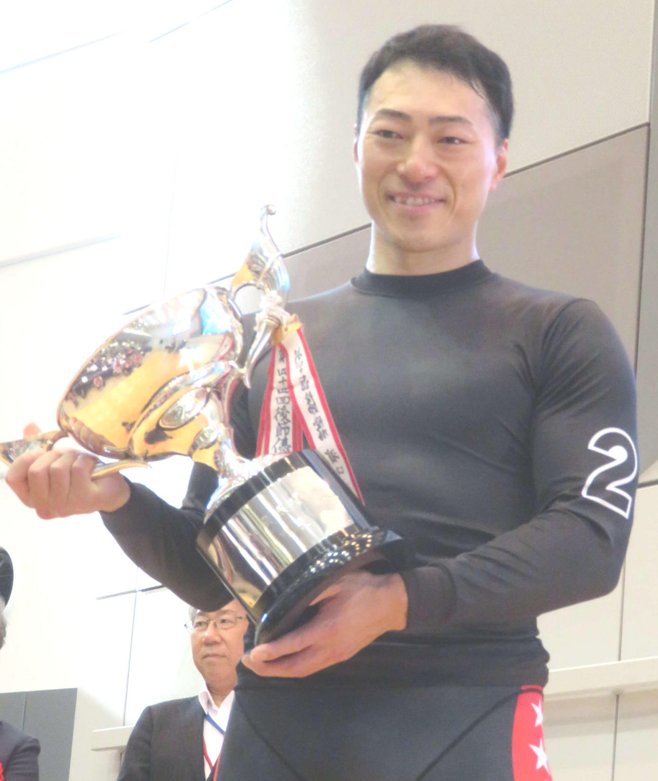 優勝カップを手に笑顔を見せる新田祐大