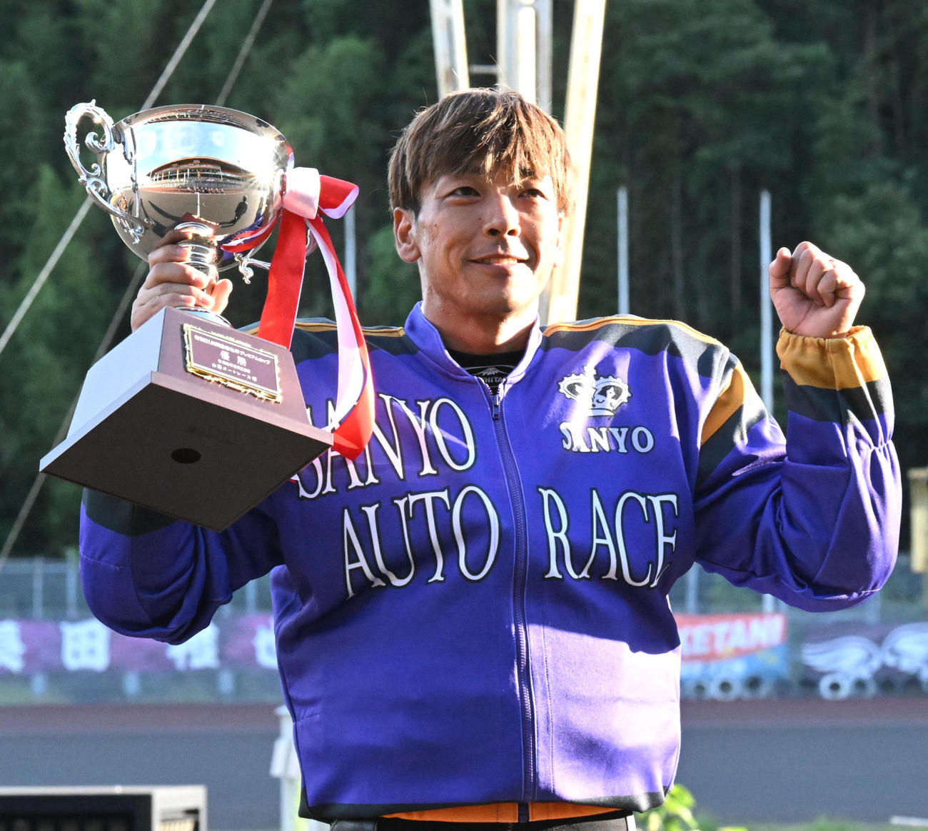 優勝カップを手に笑顔の青山周平（撮影・前岡正明）