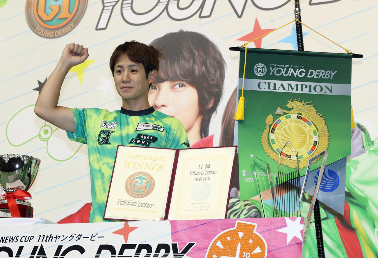 優勝した関浩哉は賞金目録を持ち記念撮影に応じる（撮影・柴田隆二）