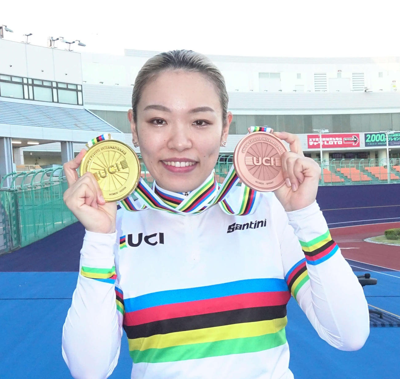 右手にケイリンの金メダル、左手にスプリントの銅メダルを持つ佐藤水菜