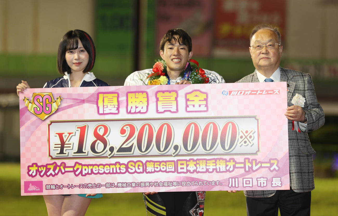 優勝した黒川京介（中央）は奥ノ木信夫川口市長（右）、川口オートレースイメージガール夜道雪と賞金ボードを持つ（撮影・柴田隆二）