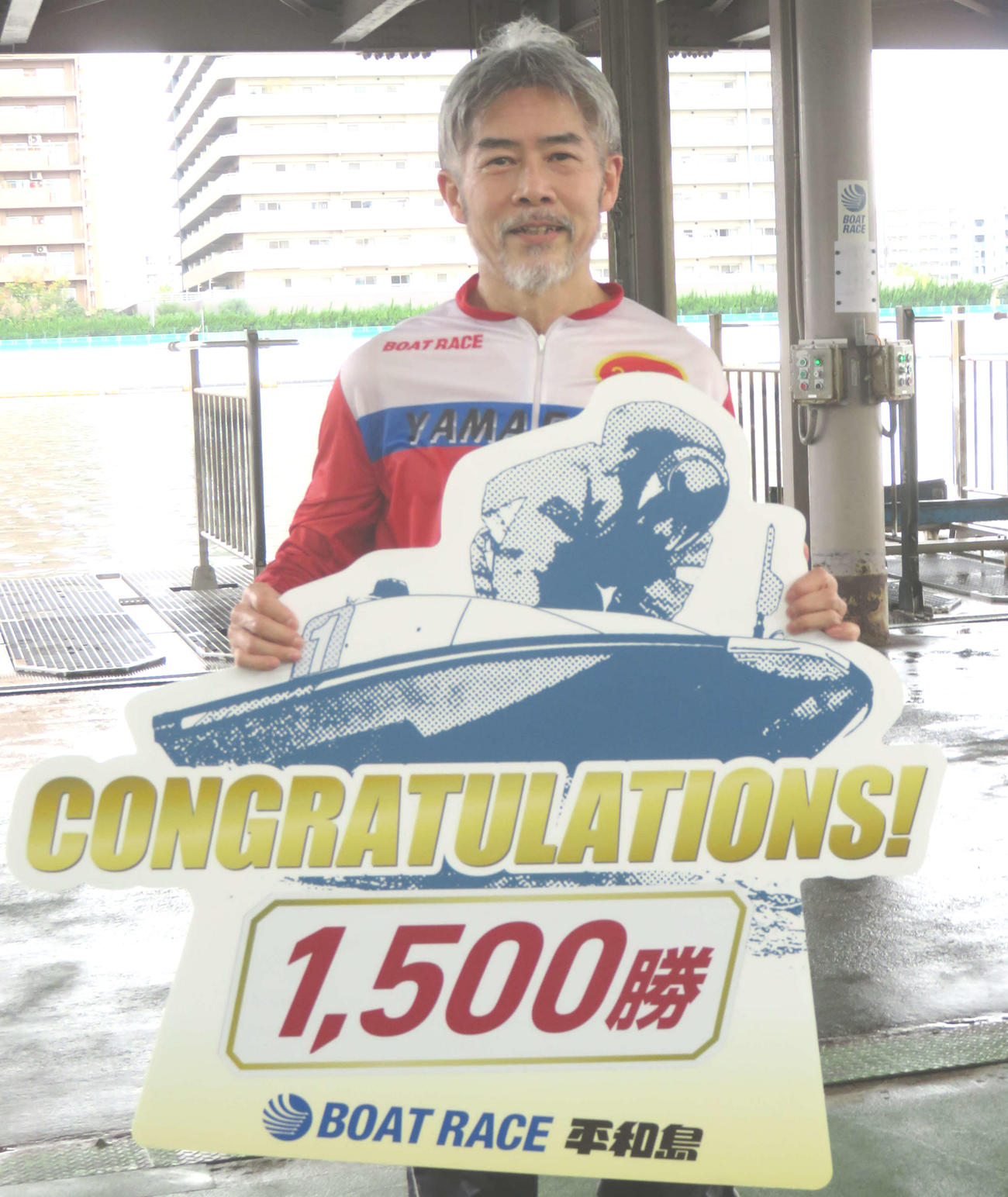 1500勝ボードを持ち笑顔の長谷川巌