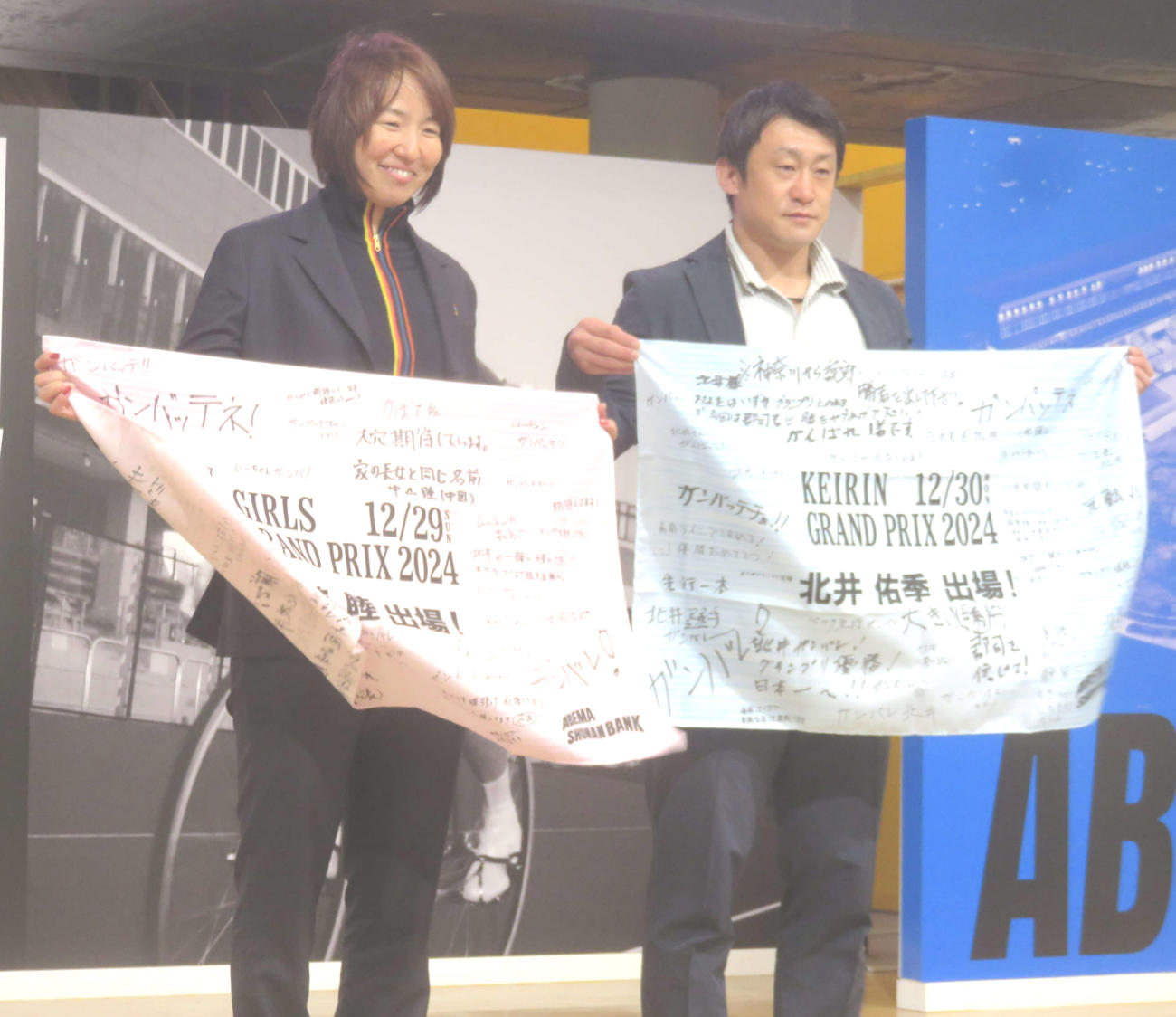 ファンから贈られた応援フラッグを手に笑顔の尾崎睦（左）と北井佑季