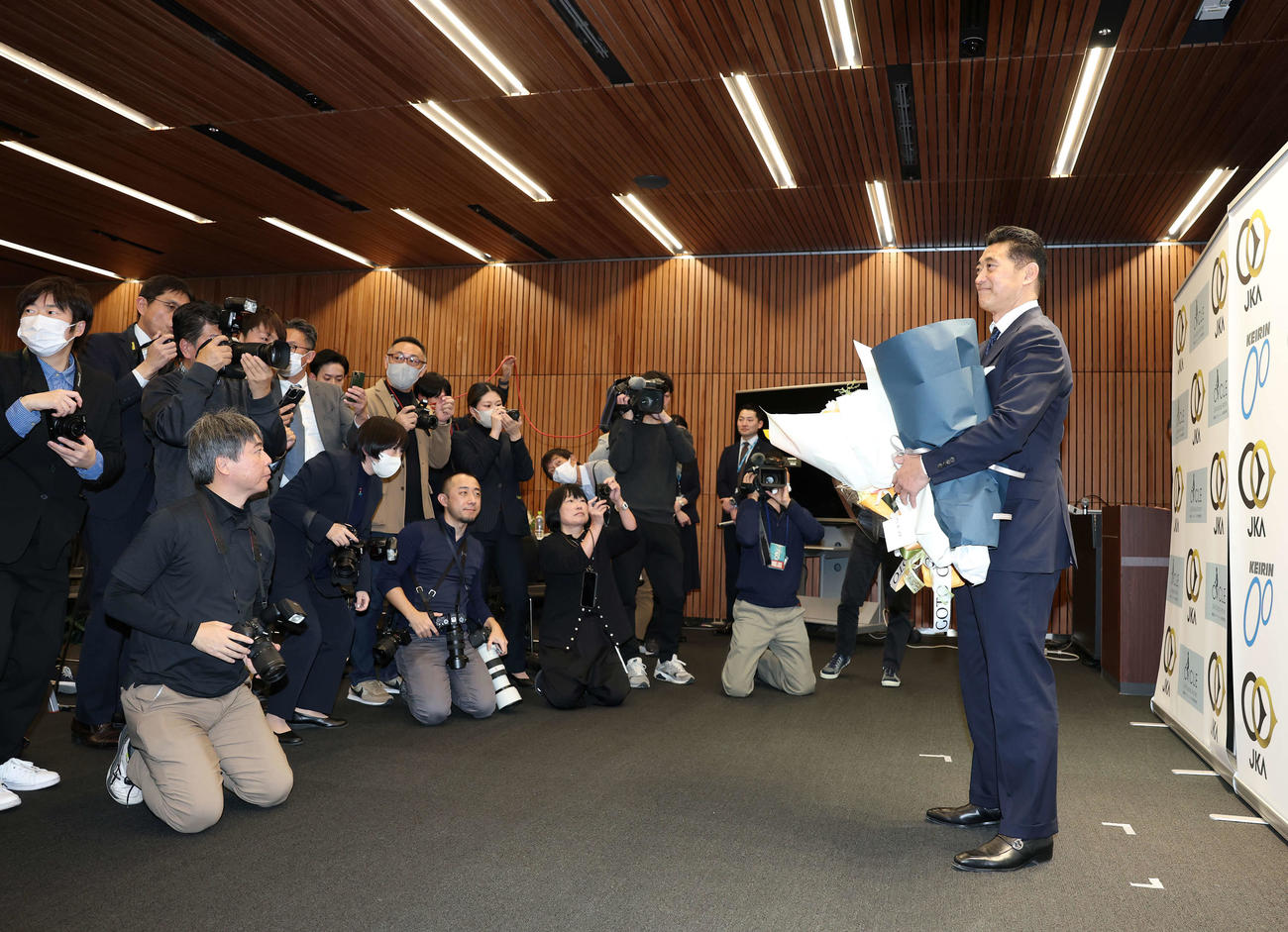 花束を手に報道陣に囲まれる神山雄一郎（撮影・鈴木正人）