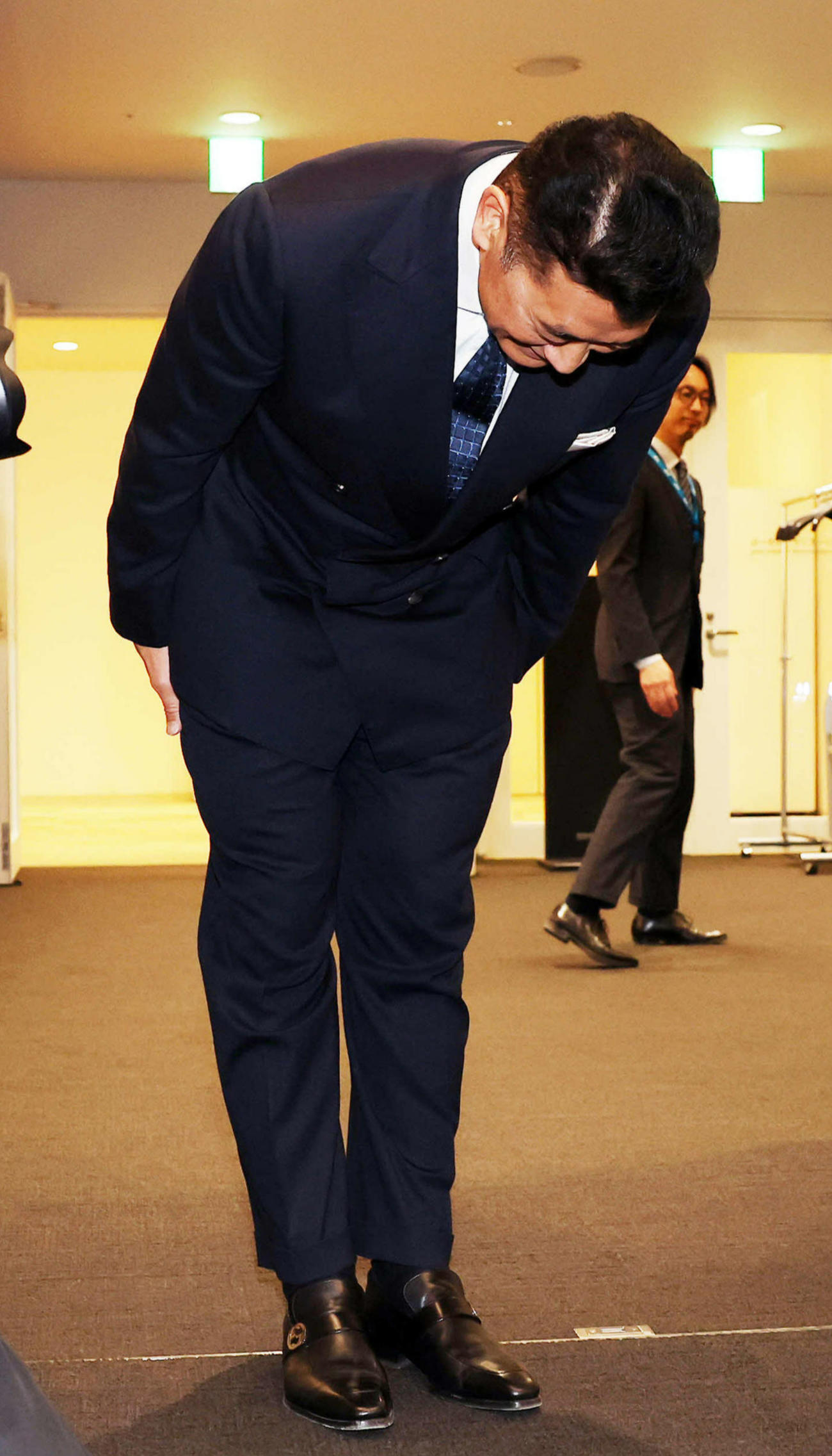 一礼して会見場から引き揚げる神山雄一郎（撮影・鈴木正人）