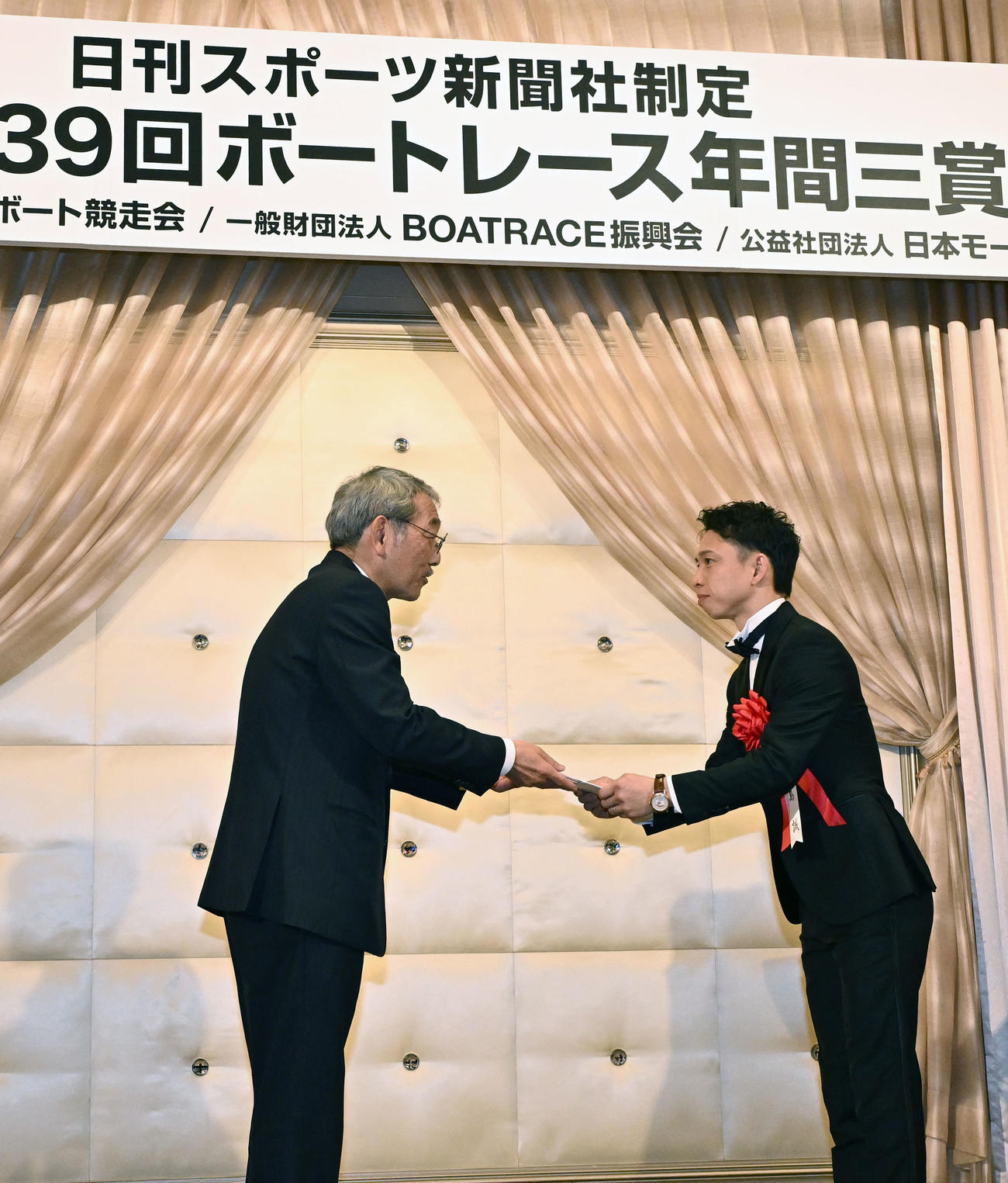 ボートレース年間三賞の表彰式で、日刊スポーツ新聞社の高田社長から殊勲賞を贈られる毒島誠（右）（撮影・千葉一成）