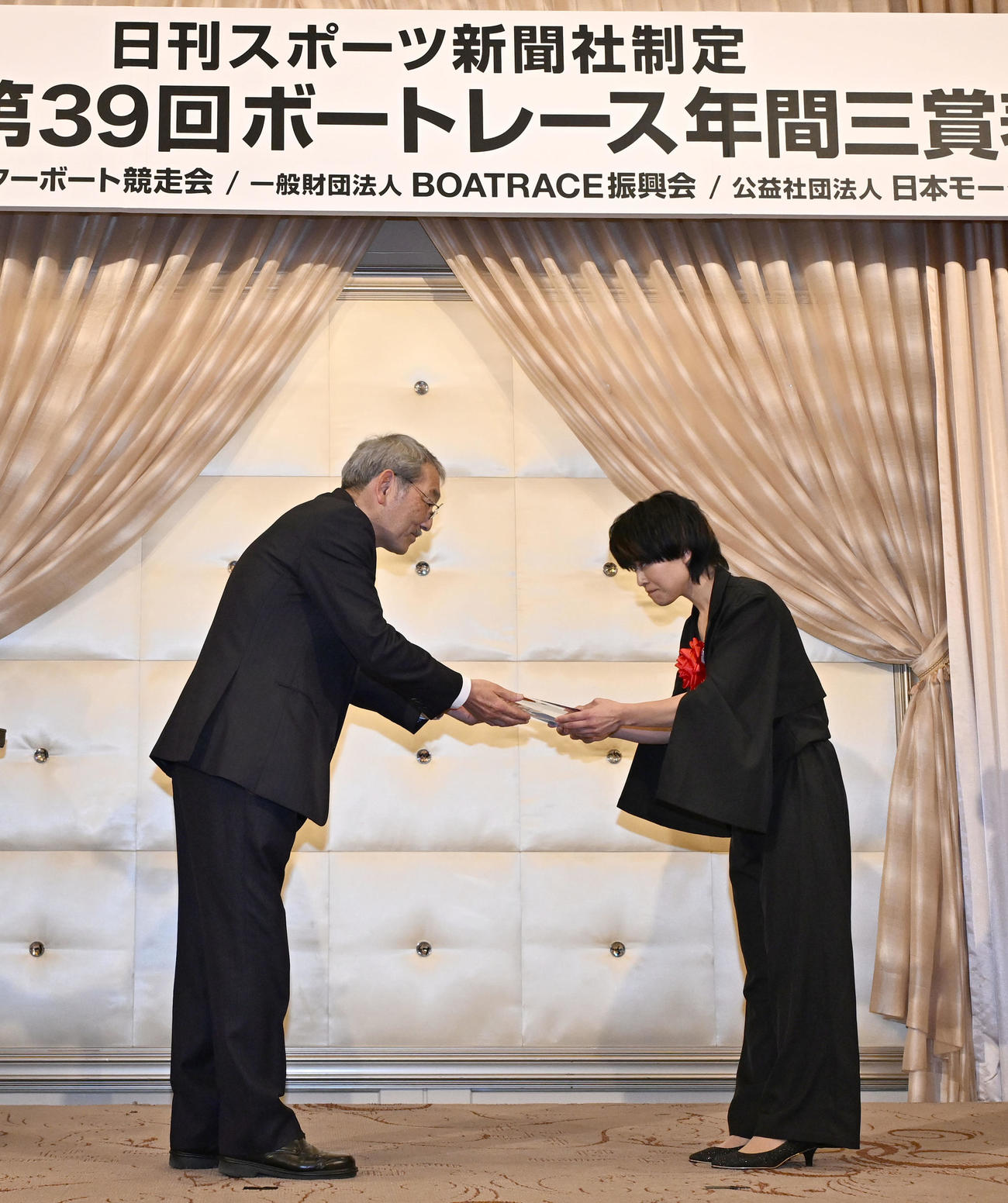 ボートレース年間三賞の表彰式で、特別賞を受賞し、日刊スポーツ新聞社の高田社長からトロフィーを贈られる遠藤エミ（右）（撮影・千葉一成）