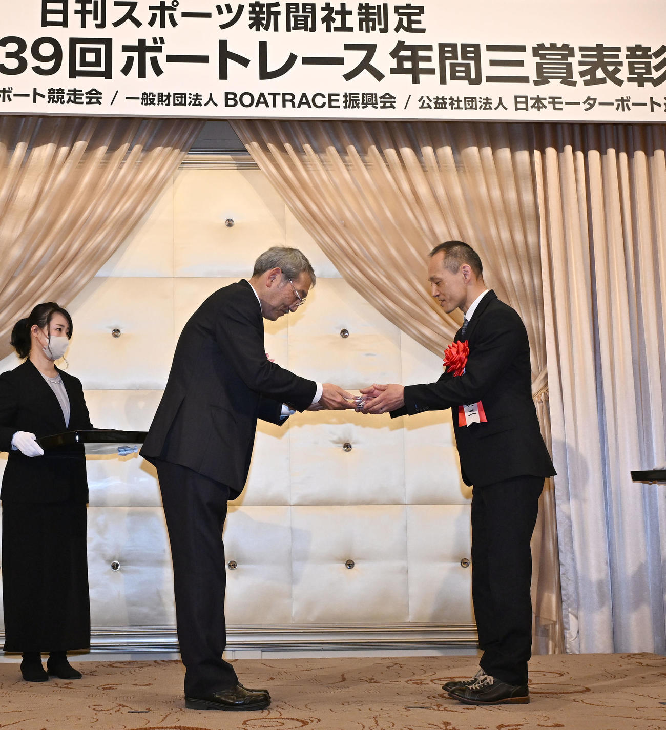 ボートレース年間三賞の表彰式で、敢闘賞を受賞し、日刊スポーツ新聞社の高田誠社長からトロフィーを贈られる石川真二（右）（撮影・千葉一成）