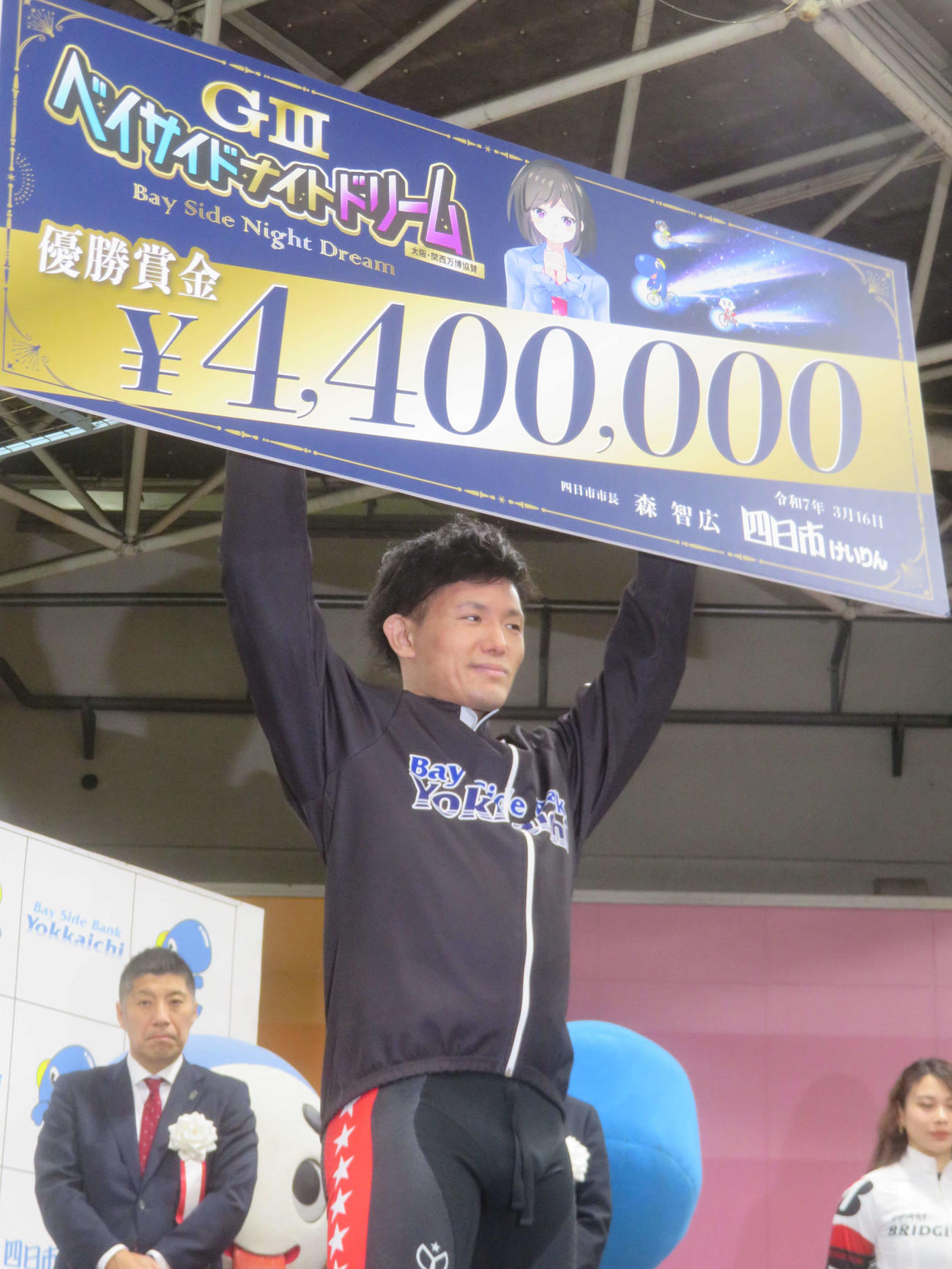 表彰式で賞金ボードを掲げる和田真久留